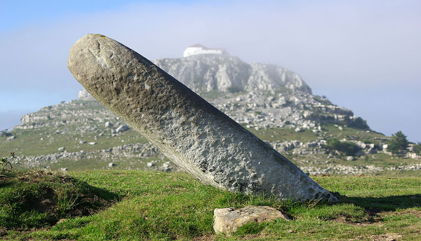 Menhir, and, in the background, Las Nieves hermitage in Guriezo